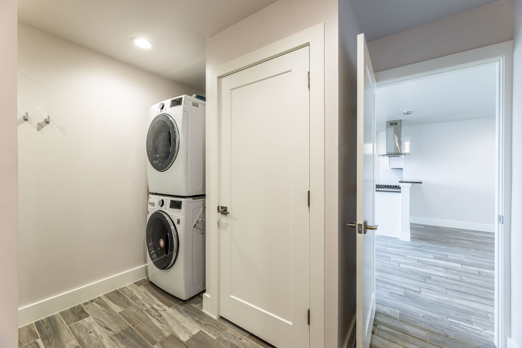 8410 Romney Road Austin, TX 78748 - Photo 16 of 35 Laundry room with light wood finished floors, stacked washing machine and dryer, and recessed lighting