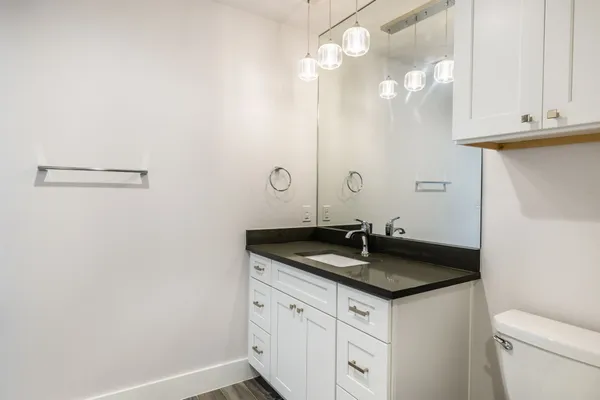 a bathroom with a granite countertop sink and a mirror