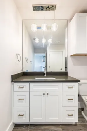a bathroom with a sink vanity granite and a mirror