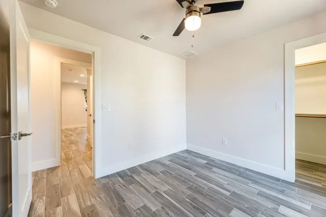 a view of a room with wooden floor and a bathroom