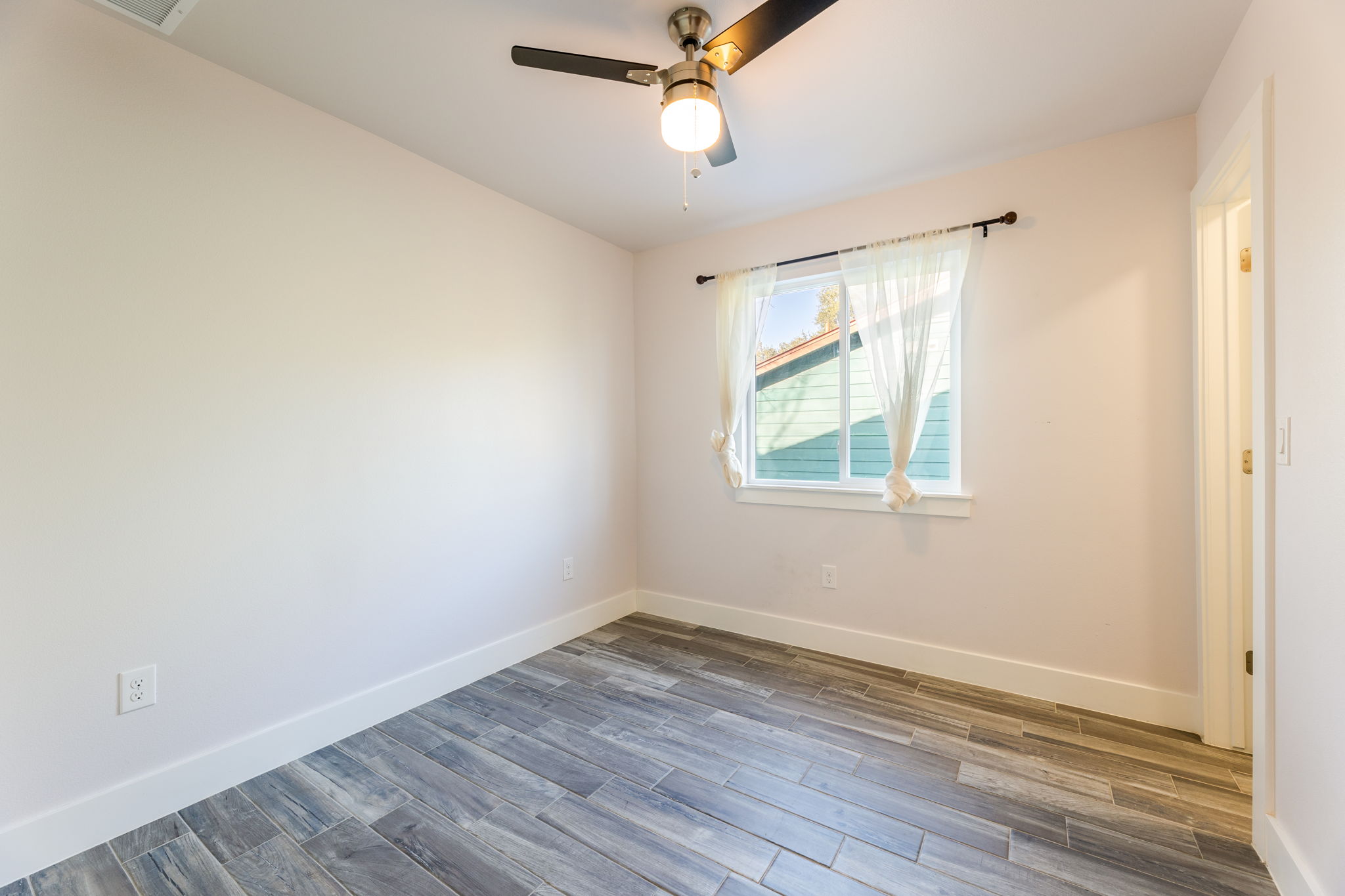 8410 Romney Road Austin, TX 78748 - Photo 23 of 35 Empty room with wood finished floors and ceiling fan