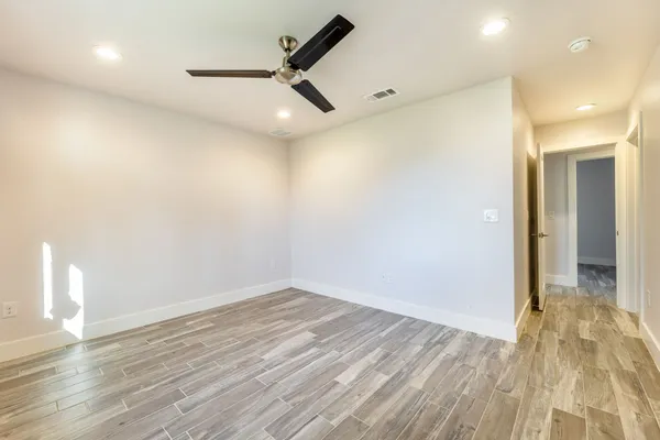 an empty room with wooden floor and windows