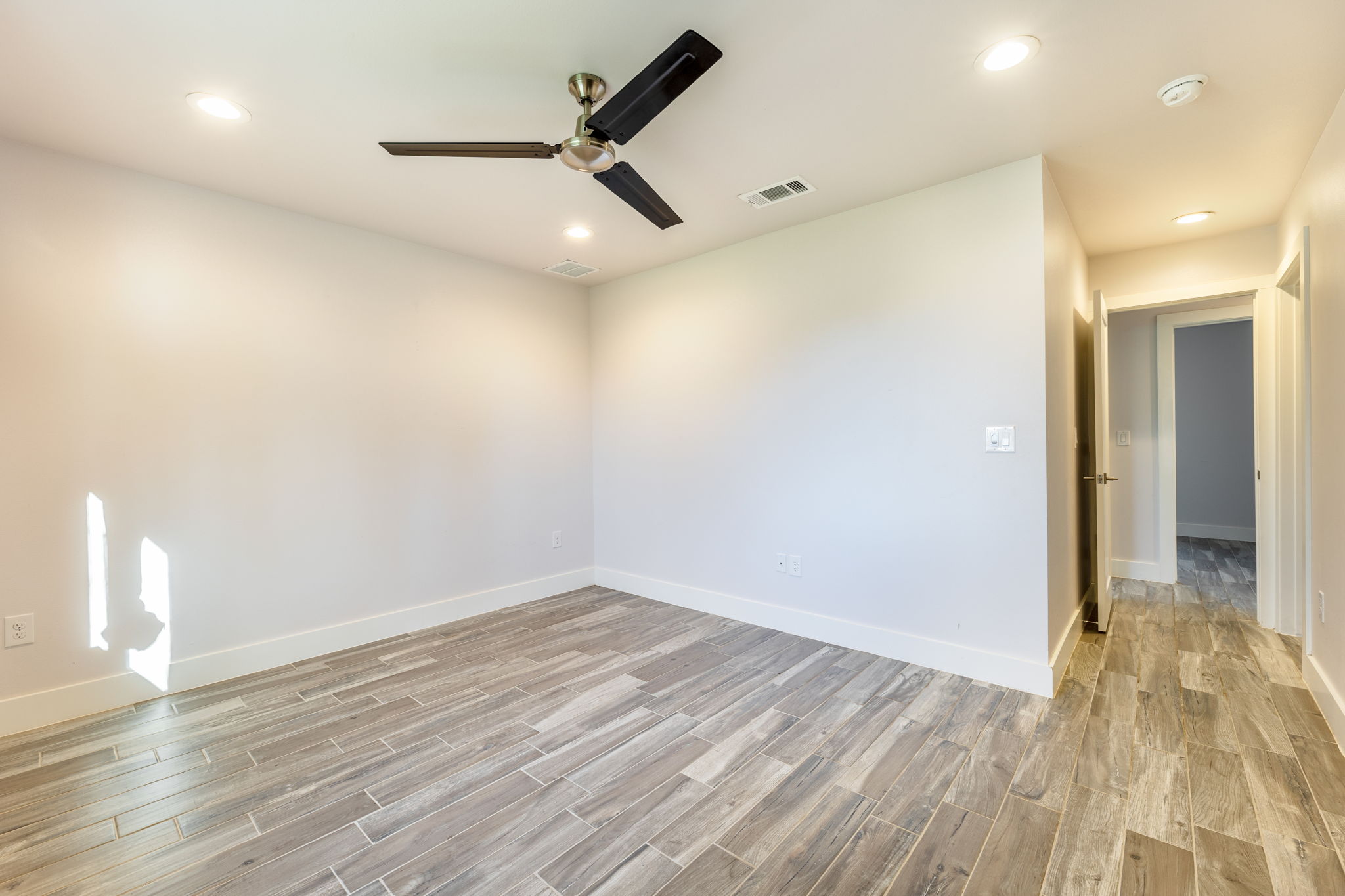 8410 Romney Road Austin, TX 78748 - Photo 26 of 35 Unfurnished room with wood tiled floors, a ceiling fan, and recessed lighting