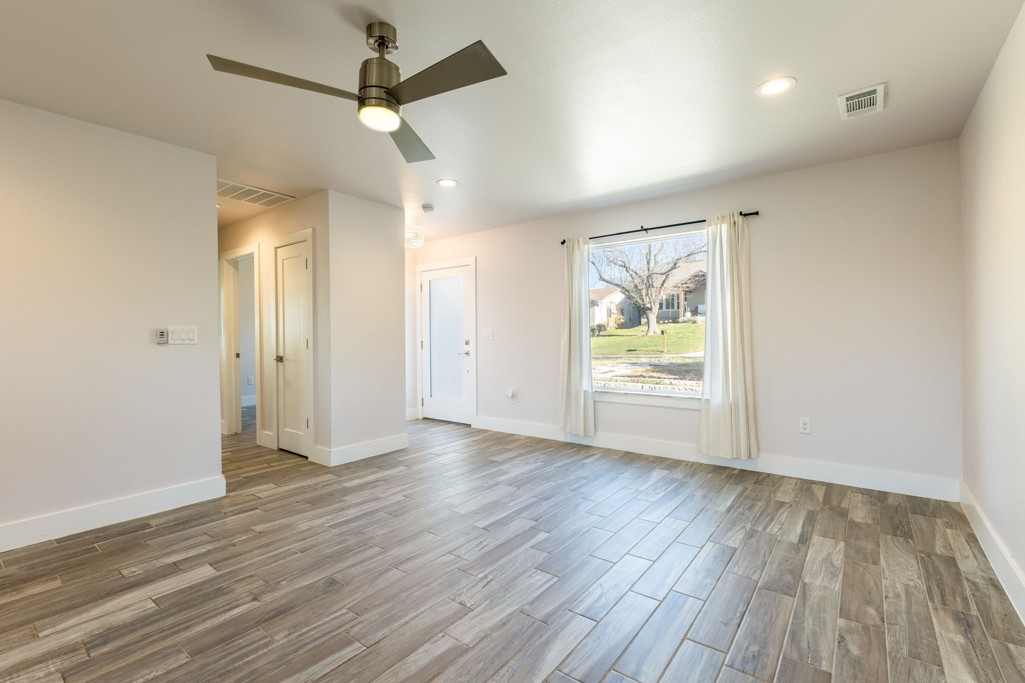 8410 Romney Road Austin, TX 78748 - Photo 7 of 35 Empty room featuring wood tiled floors, ceiling fan, and recessed lighting