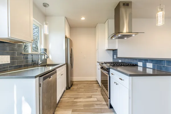 a kitchen with granite countertop a sink and stainless steel appliances
