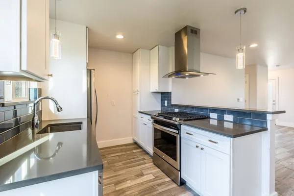 a kitchen with granite countertop a sink stainless steel appliances and cabinets
