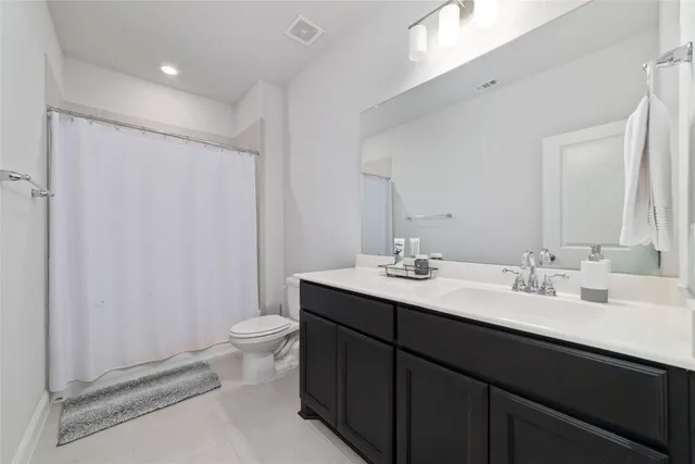 a bathroom with a double vanity sink toilet and a mirror
