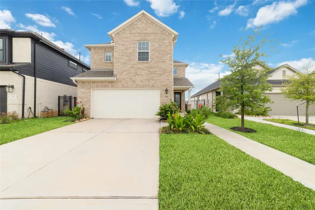 a view of a white house next to a yard with big trees