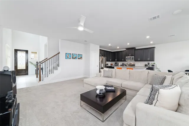 a living room with furniture kitchen view and a chandelier
