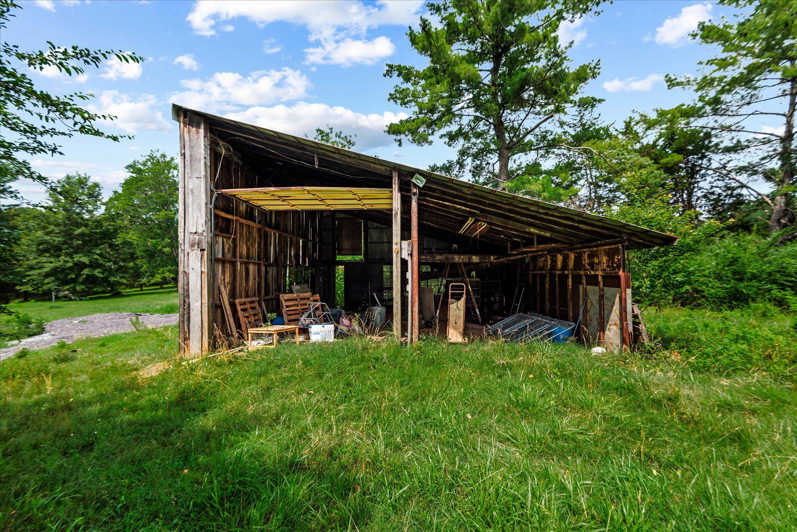 31934 Indiantown Road Locust Grove, VA 22508 - Photo 58 of 84 Rustic shed nestled in lush greenery.
