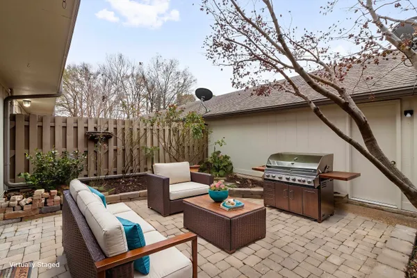 a view of a house with a small yard and a large tree