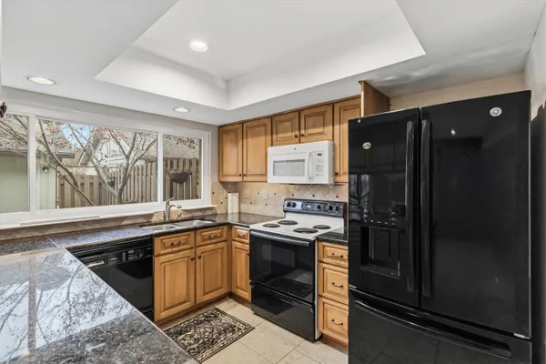 a kitchen with granite countertop a sink stove and cabinets