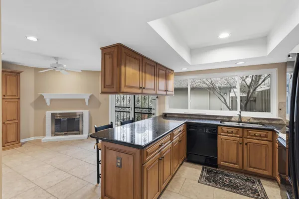 a kitchen with granite countertop a sink stove and cabinets