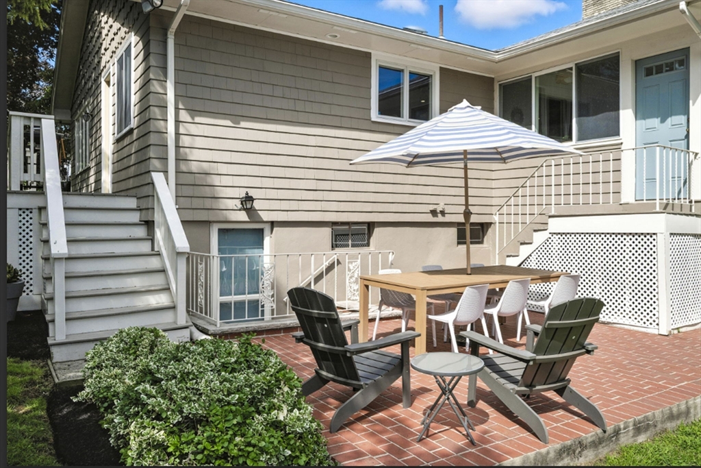 5 Yorkshire Road Marblehead, MA 01945 - Photo 33 of 37 a view of a patio with table and chairs with wooden floor and fence