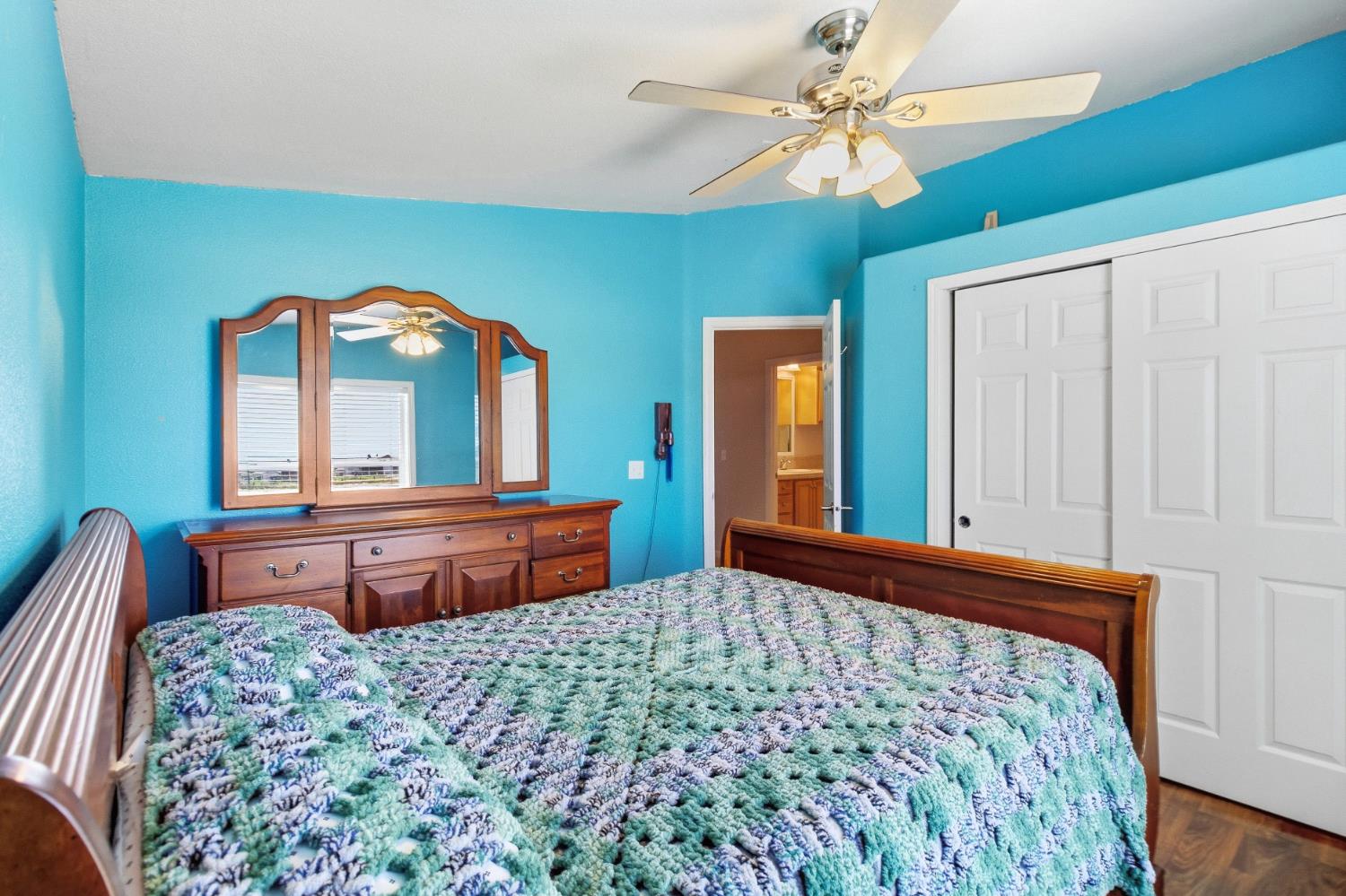 12390 Hobday Road Wilton, CA 95693 - Photo 38 of 92 a bedroom with a large bed and dresser with mirror