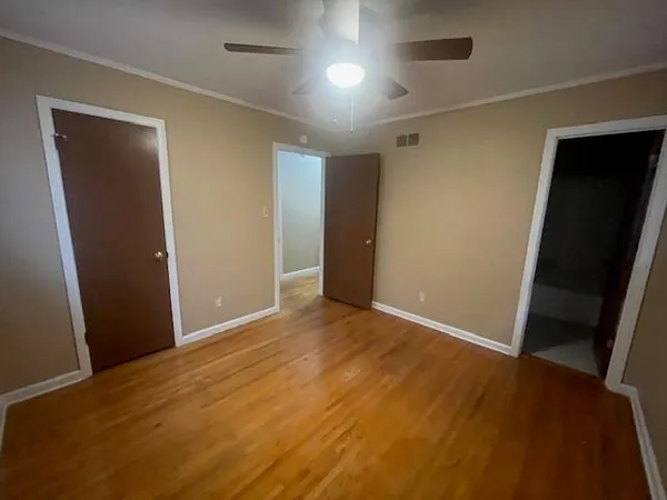 an empty room with wooden floor and closet