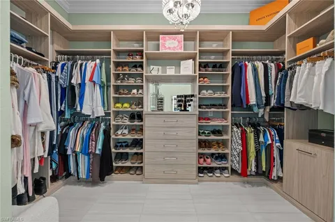 a view of walk in closet with clothes and shoes