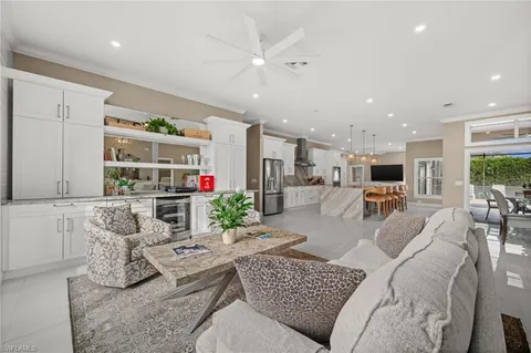 a living room with furniture kitchen view and a large window