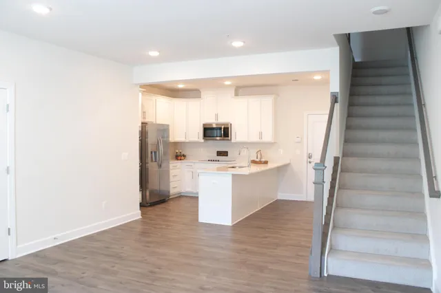 a view of kitchen with stainless steel appliances cabinets and wooden floor