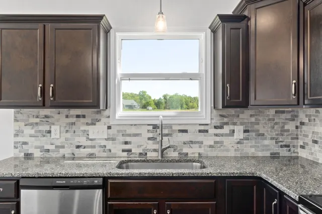 a kitchen with granite countertop a sink and a window