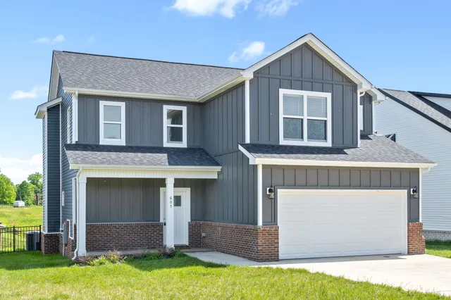 a front view of a house with a yard and garage