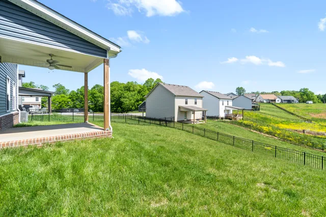 a view of a house with a big yard and large tree