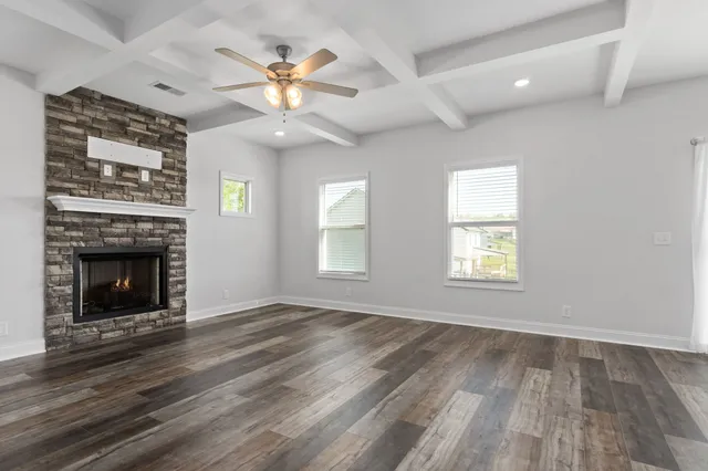 an empty room with windows and a fireplace