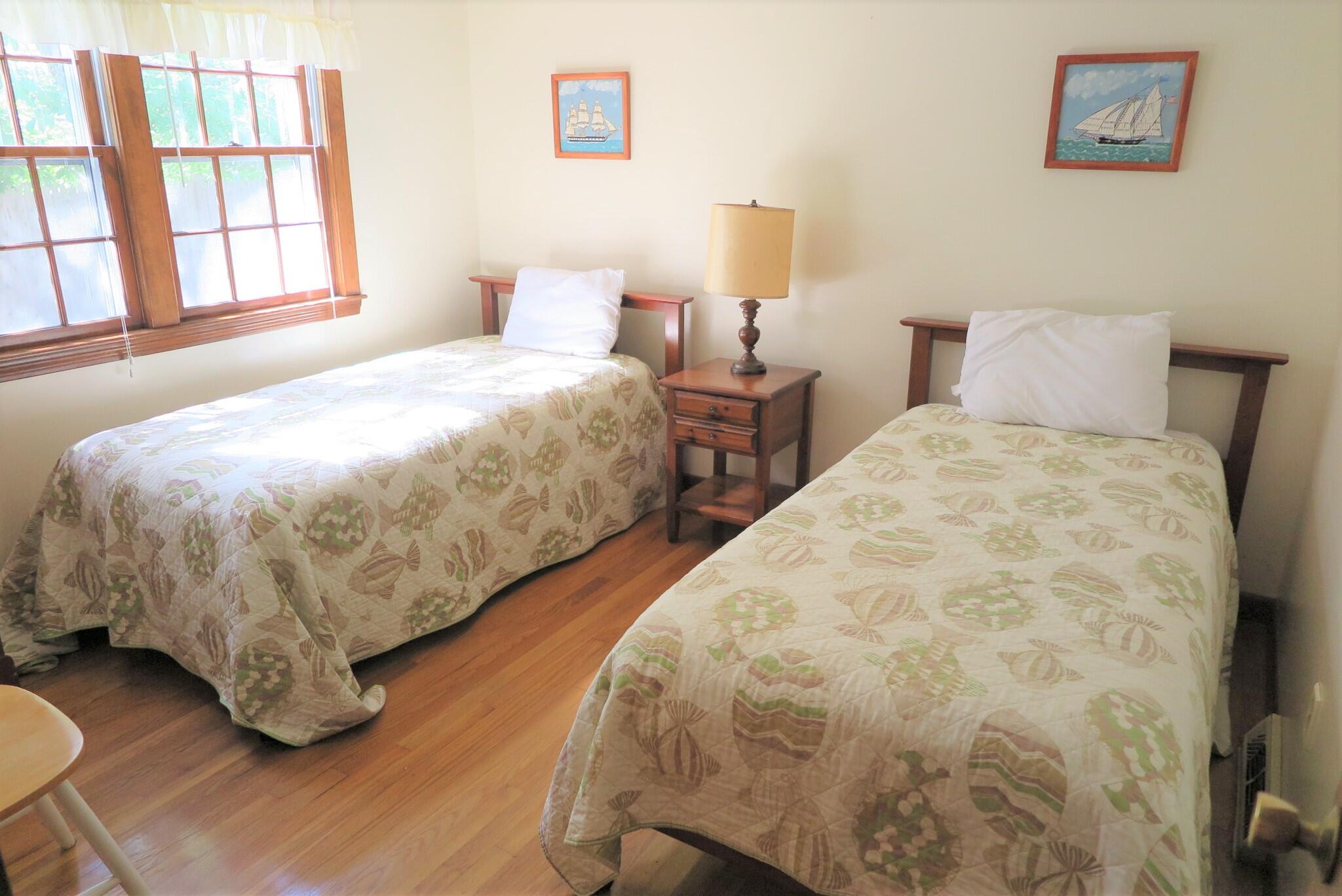 139 Captain Chase Road Dennis Port, MA 02639 - Photo 17 of 32 a large bed sitting in a bedroom next to a window with a lamp