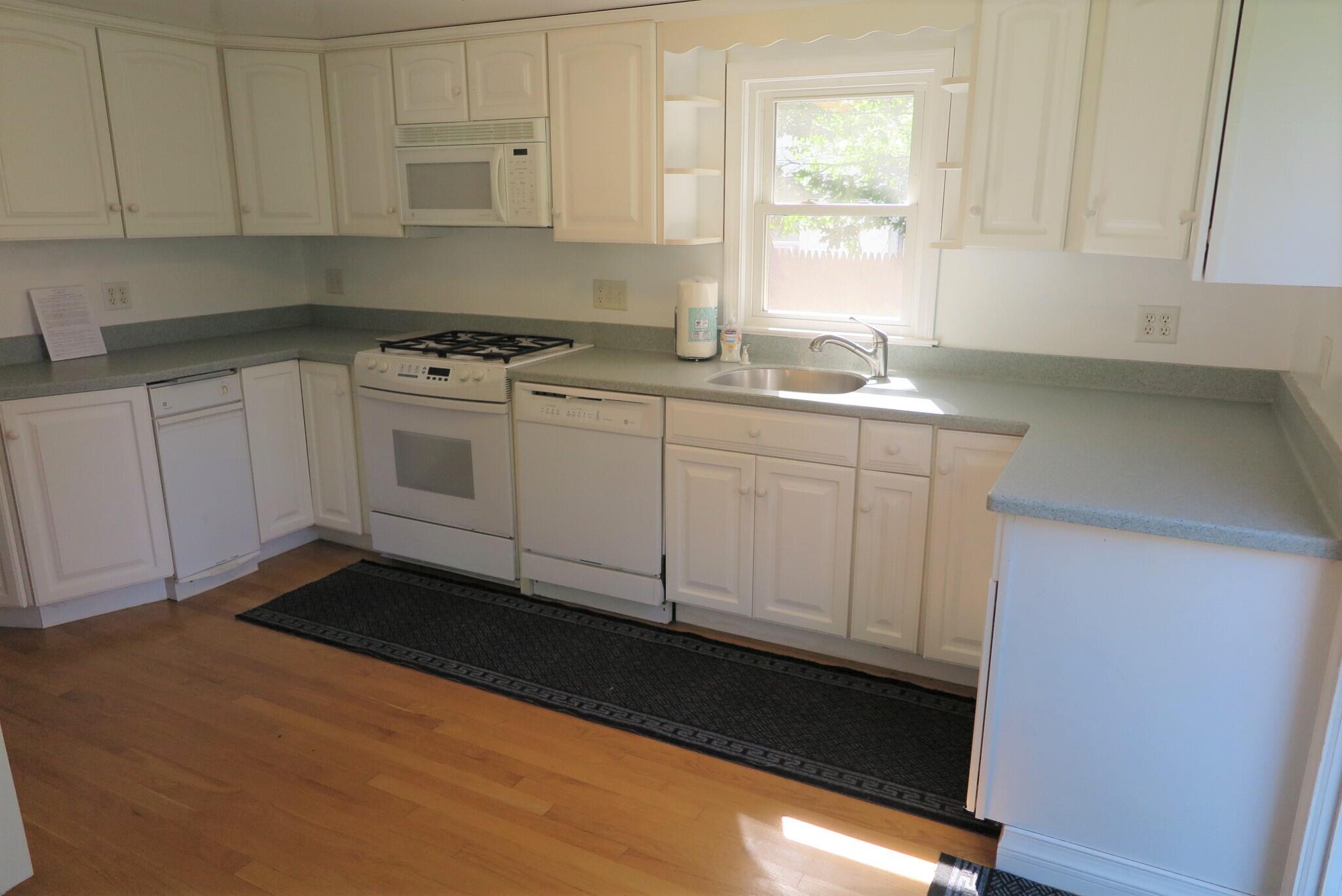139 Captain Chase Road Dennis Port, MA 02639 - Photo 2 of 32 a kitchen with granite countertop white cabinets and white appliances