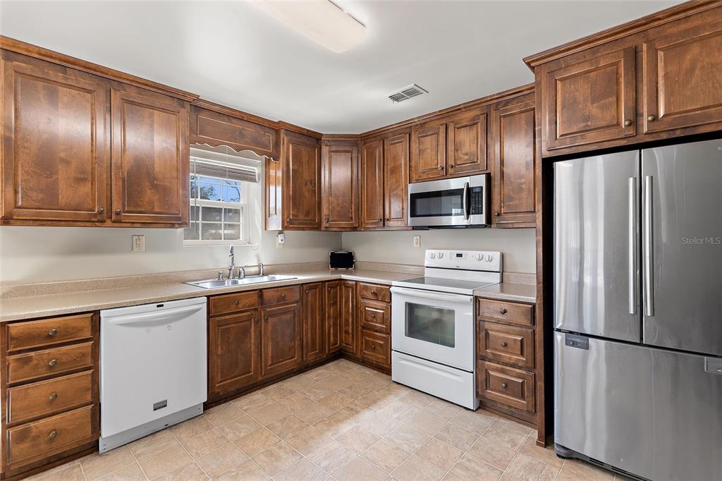 19550 Jody Morgan Road Perry, FL 32348 - Photo 62 of 79 a kitchen with granite countertop stainless steel appliances a refrigerator stove top oven and cabinets