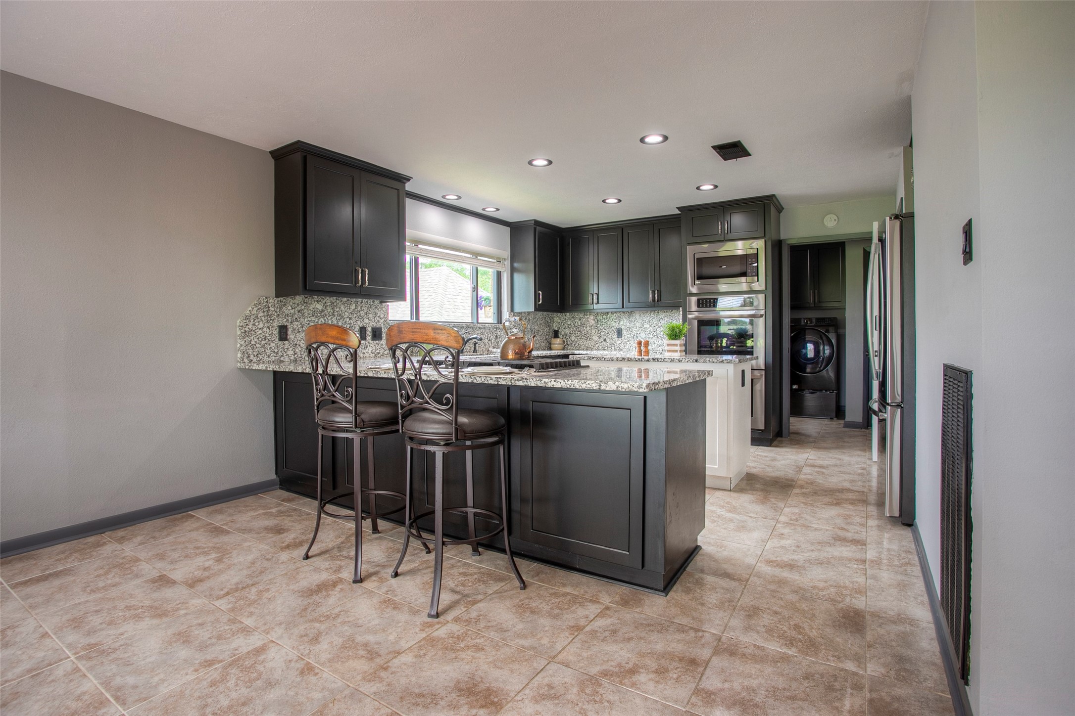 479 Cherry Hills Drive Huntsville, TX 77340 - Photo 22 of 49 a kitchen with stainless steel appliances a sink a stove a refrigerator cabinets and a dining table