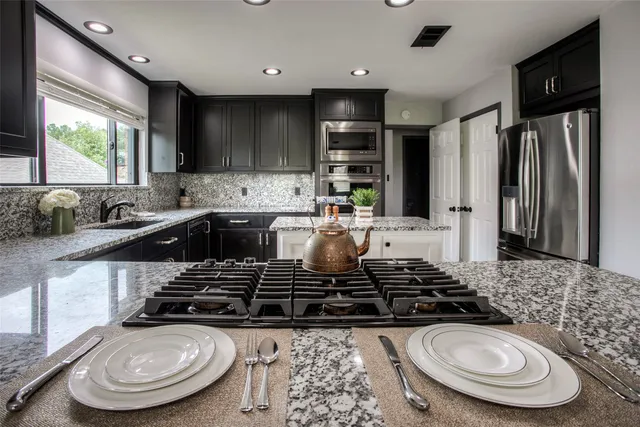 a kitchen with sink stove and refrigerator