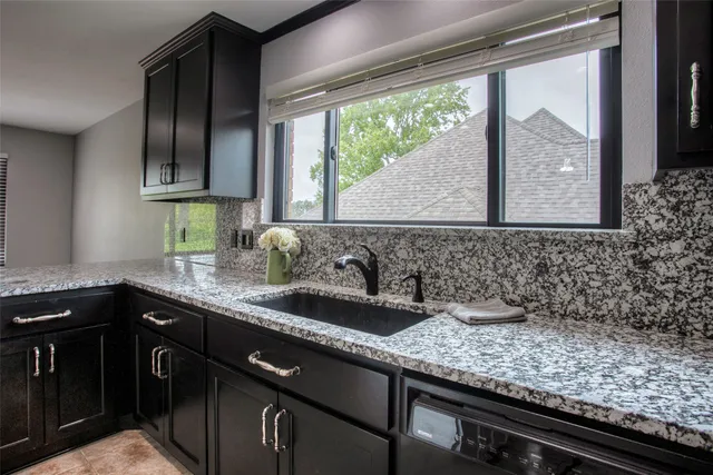 a kitchen with granite countertop stainless steel appliances a sink and wooden cabinets