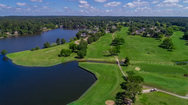 an aerial view of a house with a garden and lake view