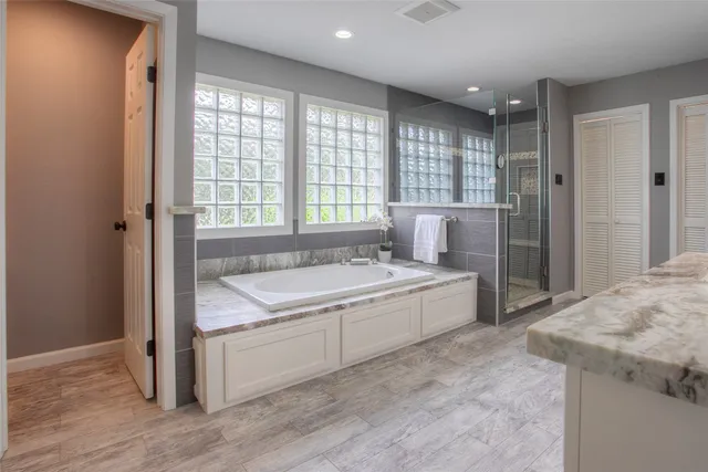 a bathroom with a granite countertop sink and a bathtub
