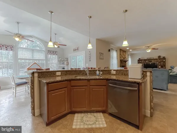 a kitchen with kitchen island granite countertop a sink a counter space appliances and a floor