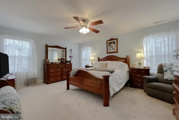 a spacious bedroom with a bed couch and dresser