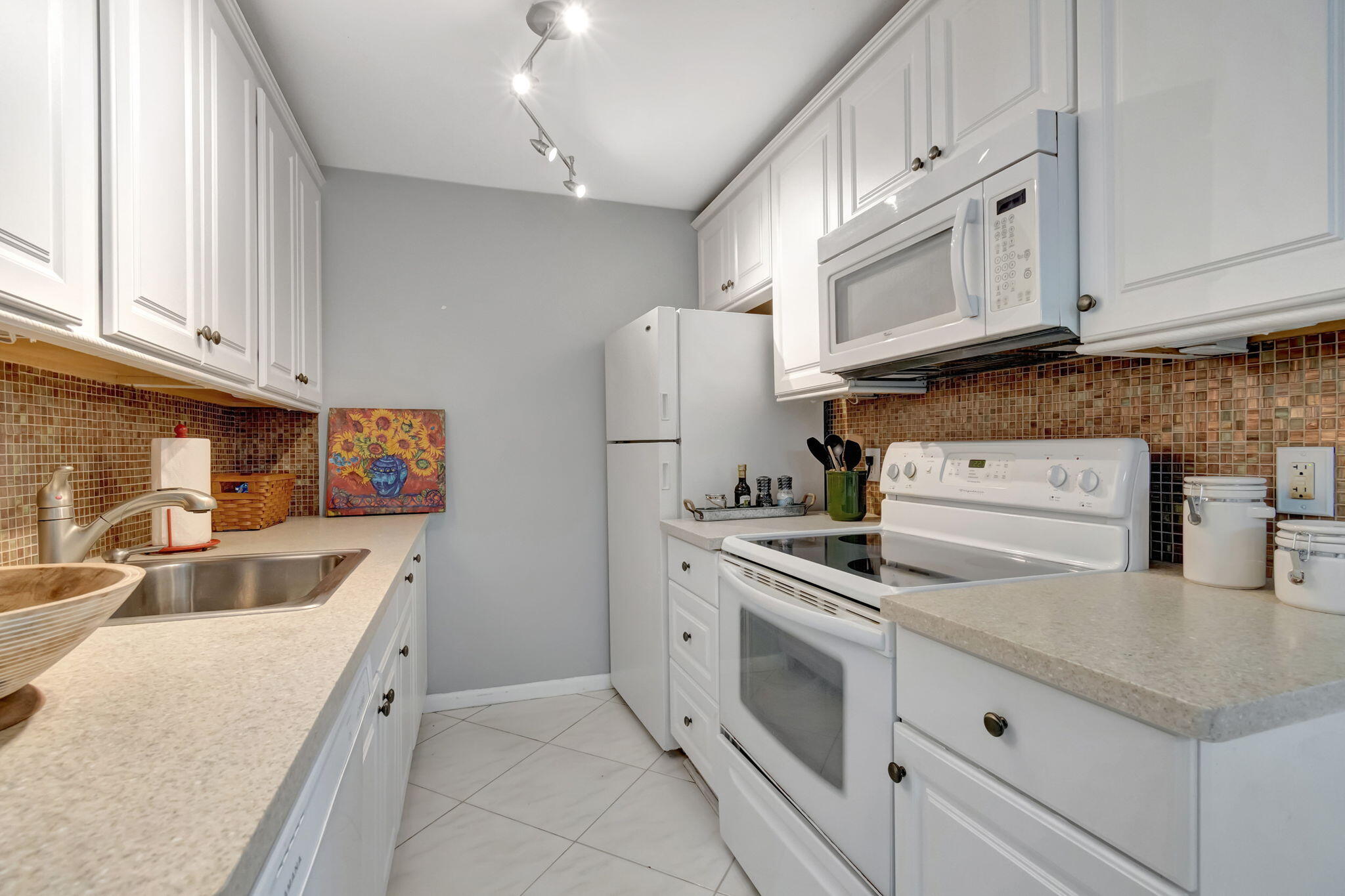 3031 Cornwall East Boca Raton, FL 33434 - Photo 9 of 84 a kitchen with white cabinets and white appliances