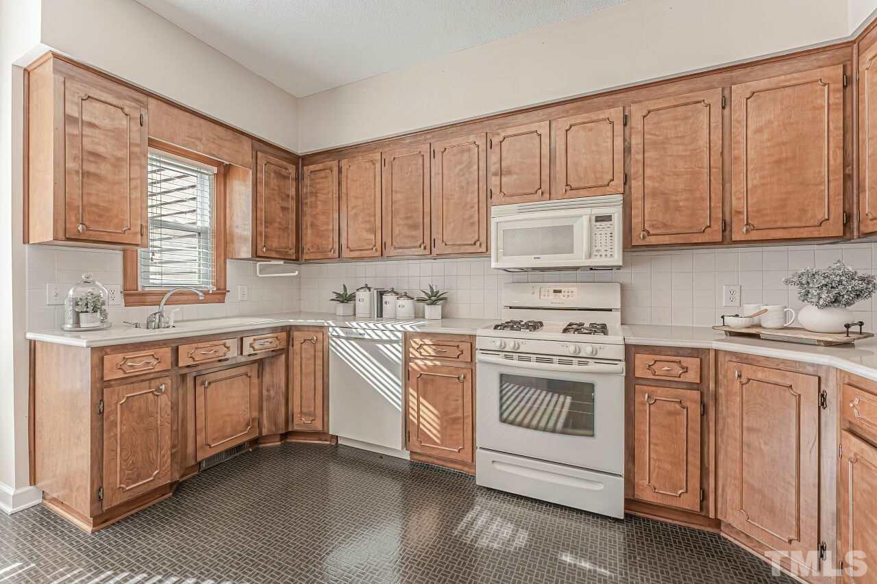 2616 Sawmill Road Raleigh, NC 27613 - Photo 2 of 18 a kitchen with granite countertop white cabinets and white appliances