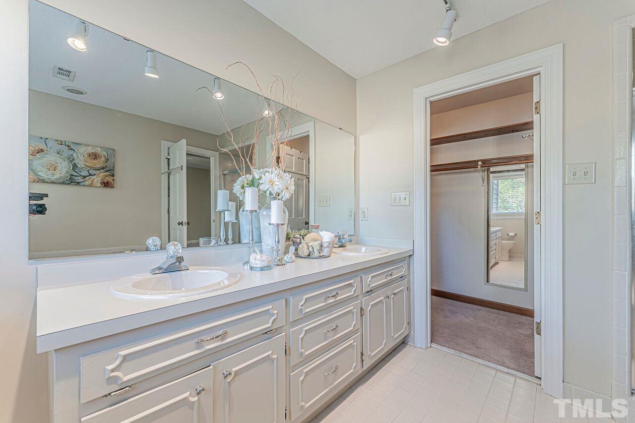 2616 Sawmill Road Raleigh, NC 27613 - Photo 13 of 18 a bathroom with a double vanity sink and a mirror