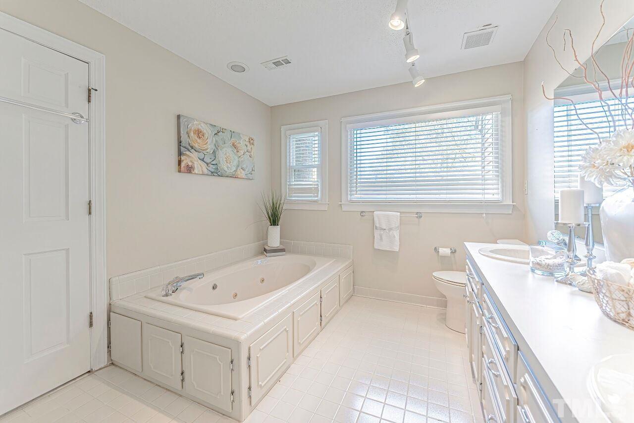 2616 Sawmill Road Raleigh, NC 27613 - Photo 14 of 18 a bathroom with a tub sink and mirror