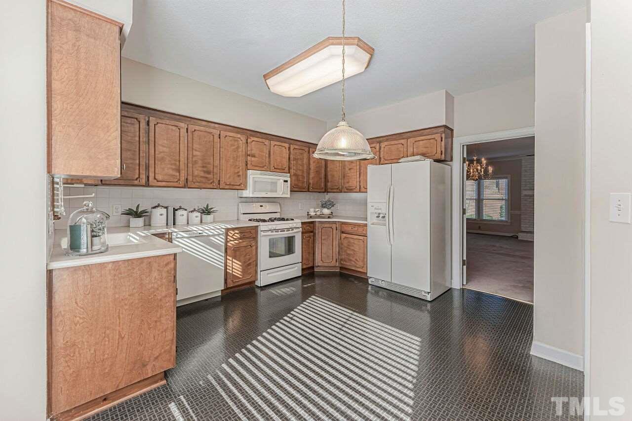 2616 Sawmill Road Raleigh, NC 27613 - Photo 4 of 18 a kitchen with stainless steel appliances a stove a sink dishwasher a refrigerator and cabinets with wooden floor