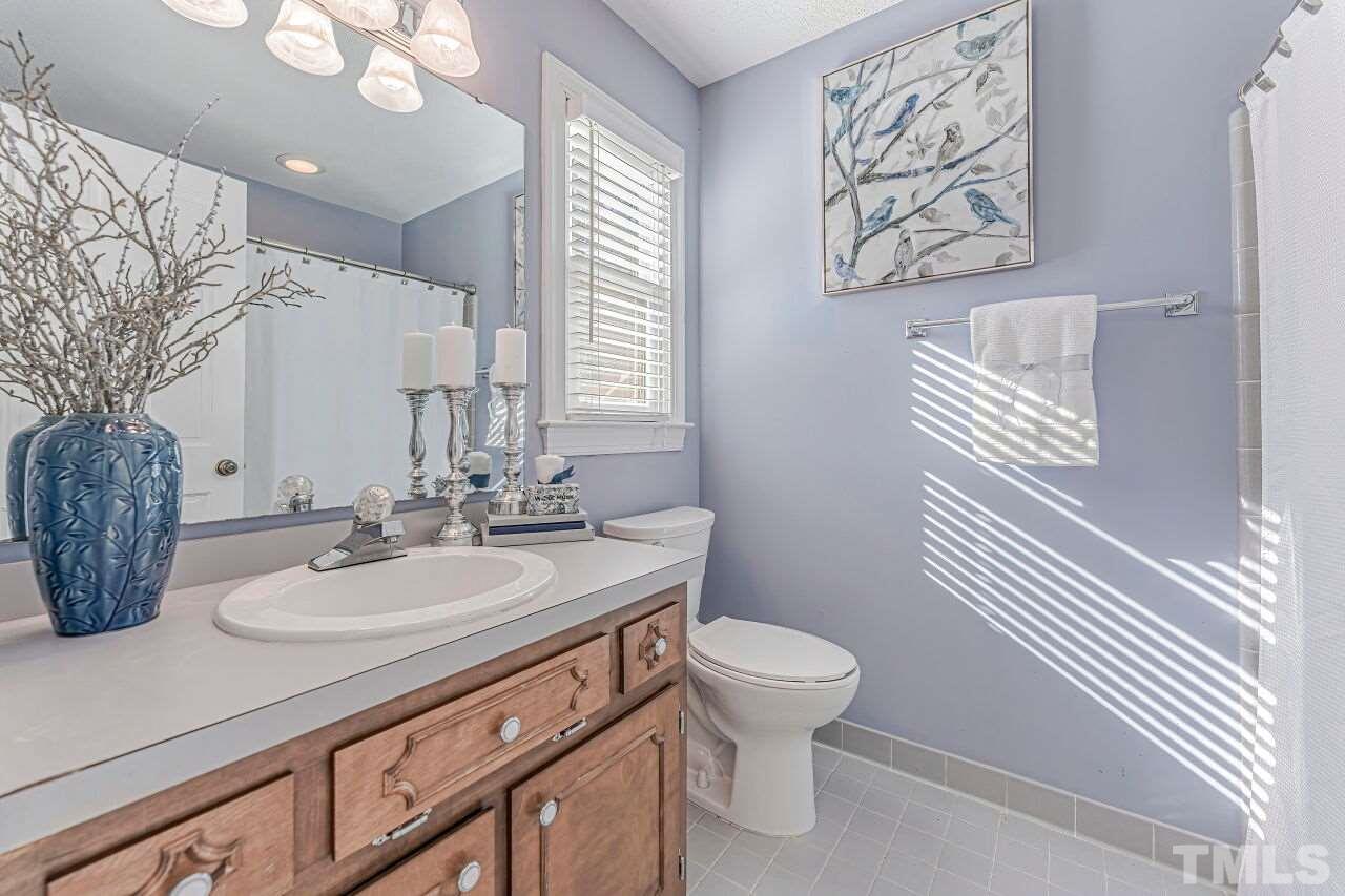2616 Sawmill Road Raleigh, NC 27613 - Photo 10 of 18 a bathroom with a toilet sink and mirror