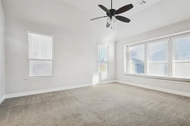 a view of an empty room with wooden floor and a fireplace