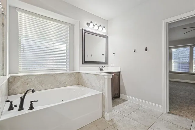 a spacious bathroom with a sink a mirror a bathtub and window