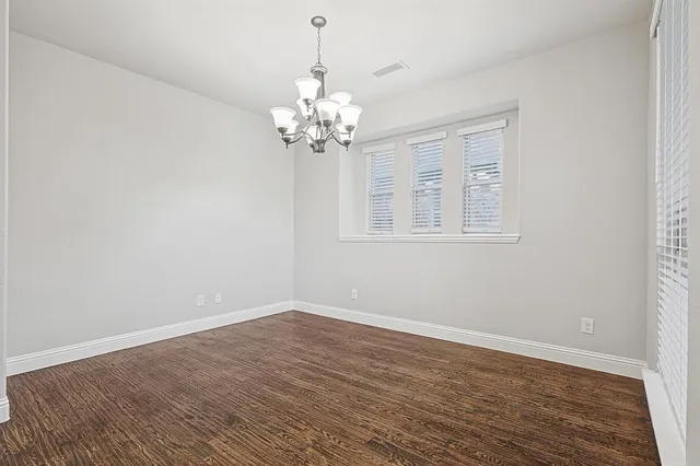 a view of a room with wooden floor and chandelier