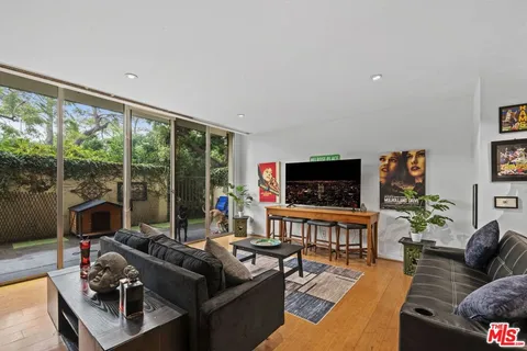 a living room with furniture a flat screen tv and a large window