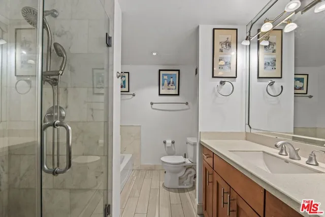 a bathroom with a granite countertop sink toilet and shower