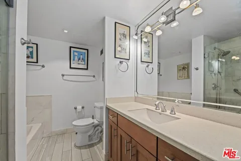 a bathroom with a granite countertop sink mirror vanity and toilet
