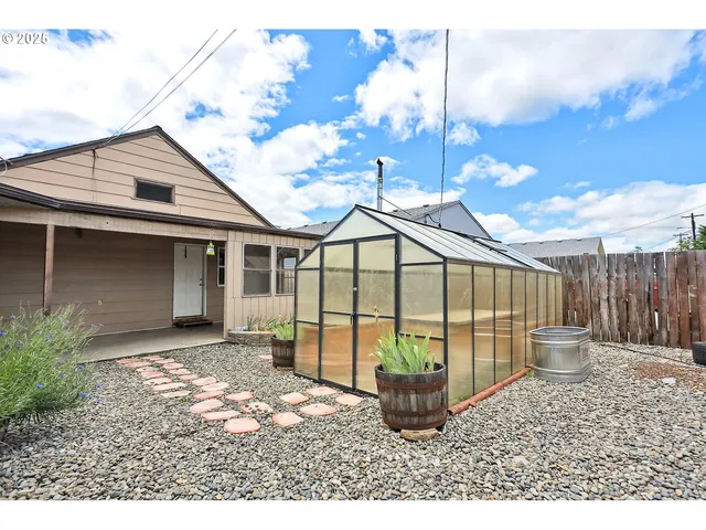 a view of backyard with a large window and wooden floor